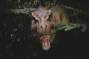 A large dinosaur with its mouth open in a forest