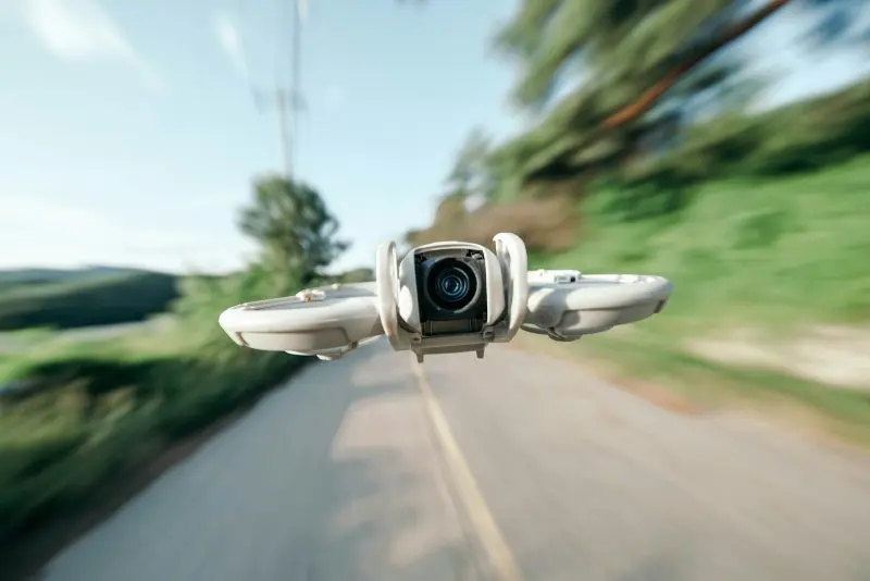 A drone flies quickly down a road.