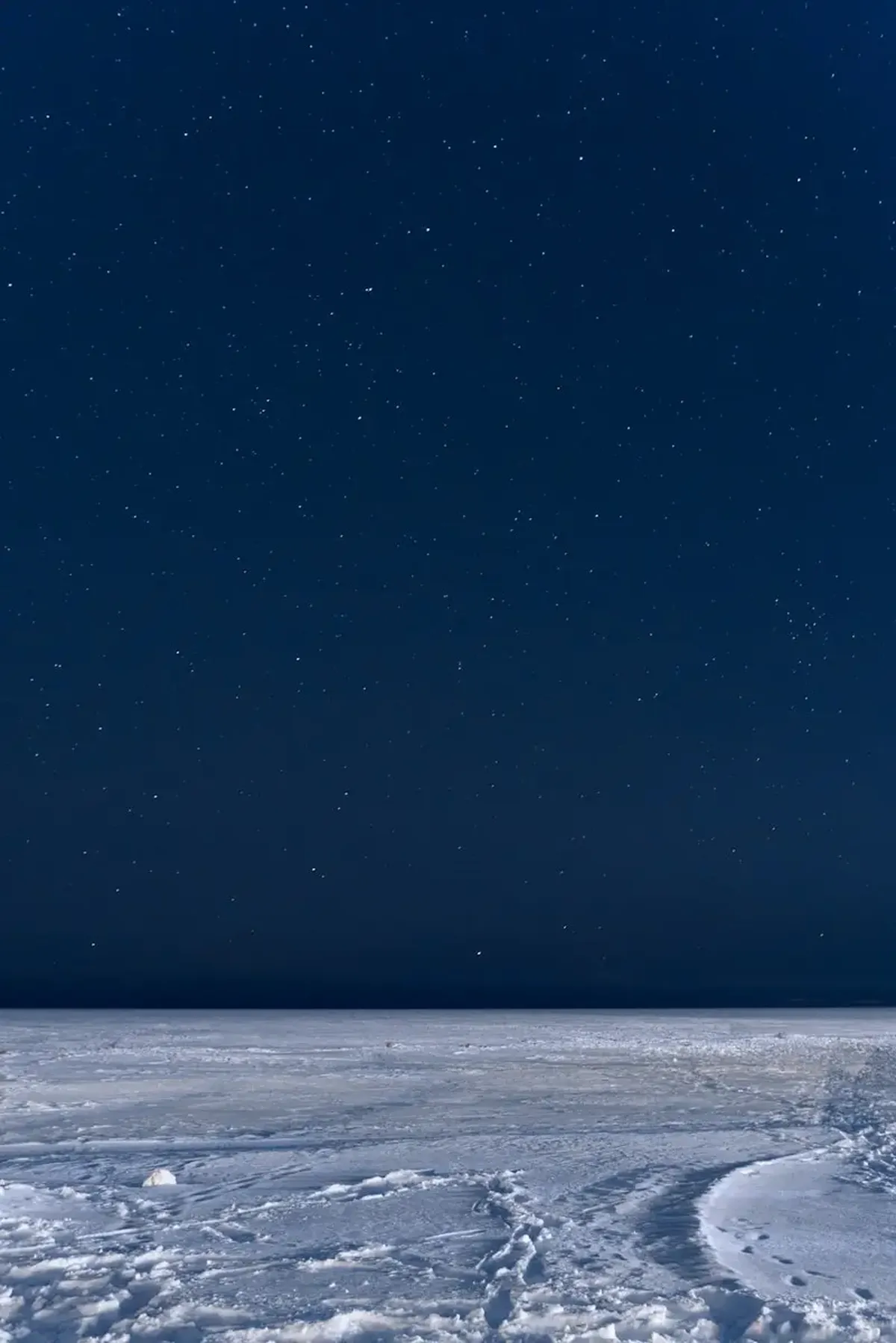 Tiny Glass Beads on the Moon Could Hold 300 Billion Tons of Water 3 The night sky is full of stars above a vast expanse of snow.