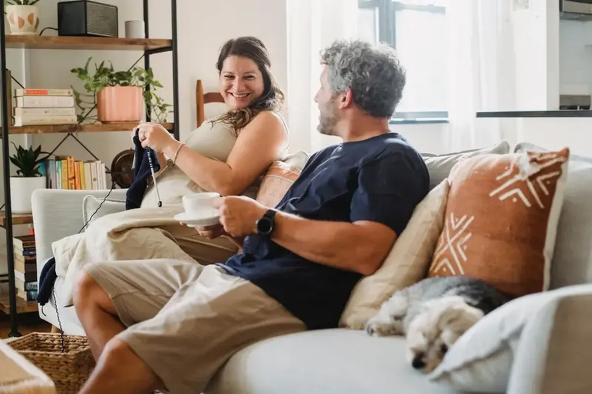 How Gossip Can Strengthen Your Relationship 3 A couple talking while seated on a couch.