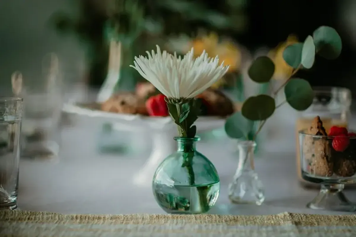 The Small Rules of Hosting: Seating, Flowers, and Relaxation Corners 4 A white flower in a green glass vase