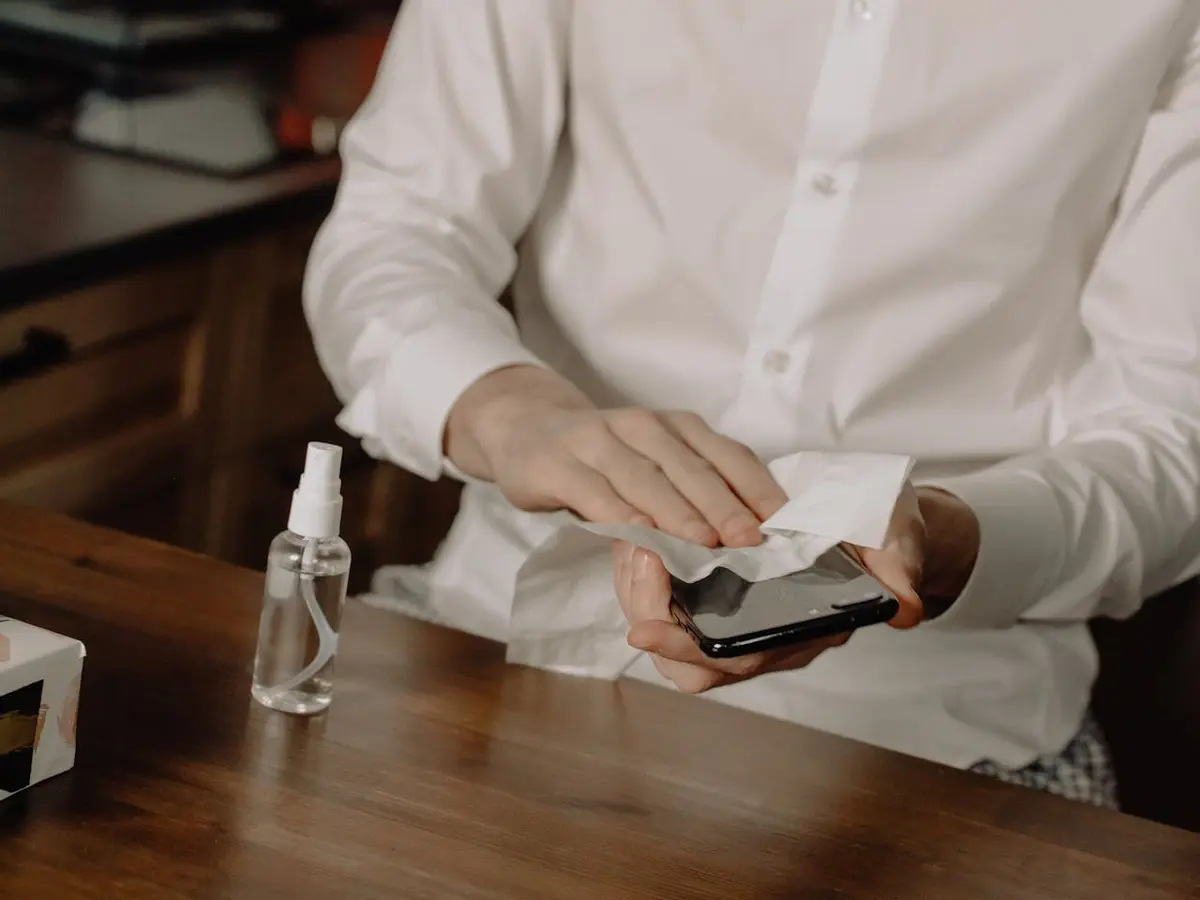 Your Phone Is Teeming with Germs — How to Clean It Safely 5 Wiping a phone with a cloth