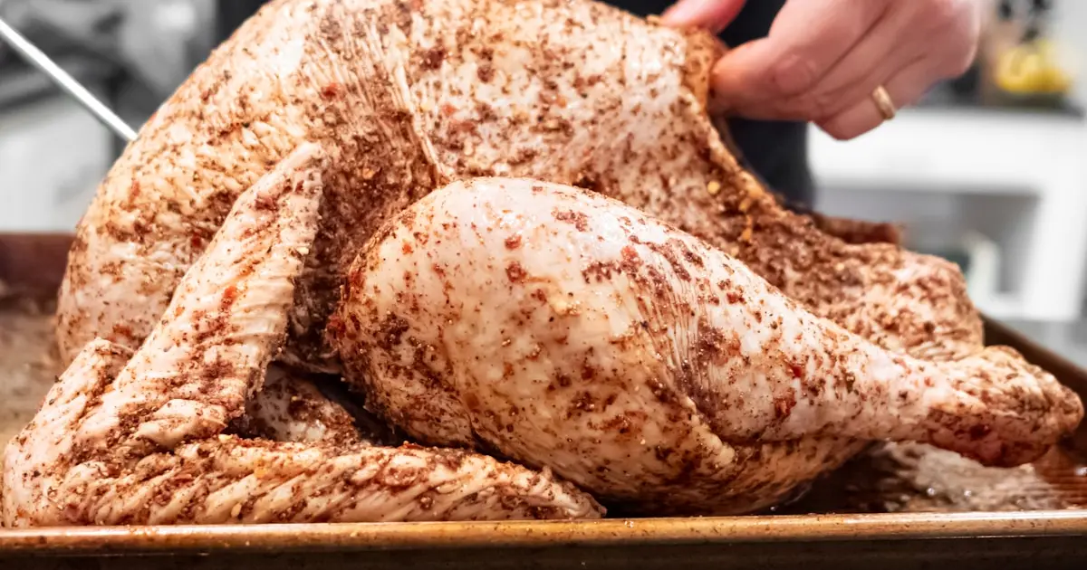A person carving a turkey on a tray.