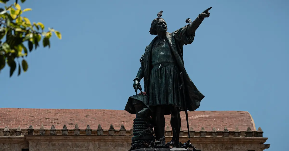 How Columbus Sent a Message in a Coconut That Was Found 350 Years Later 3 black statue of a man holding a yellow umbrella