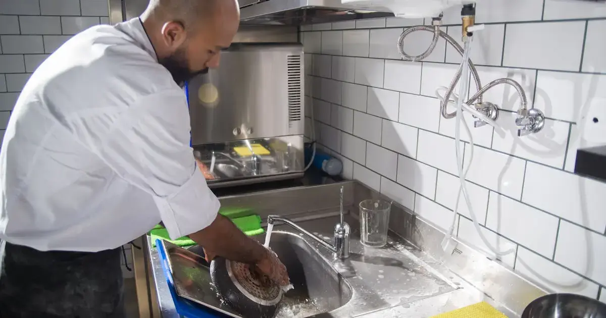 A chef washing a frying pan