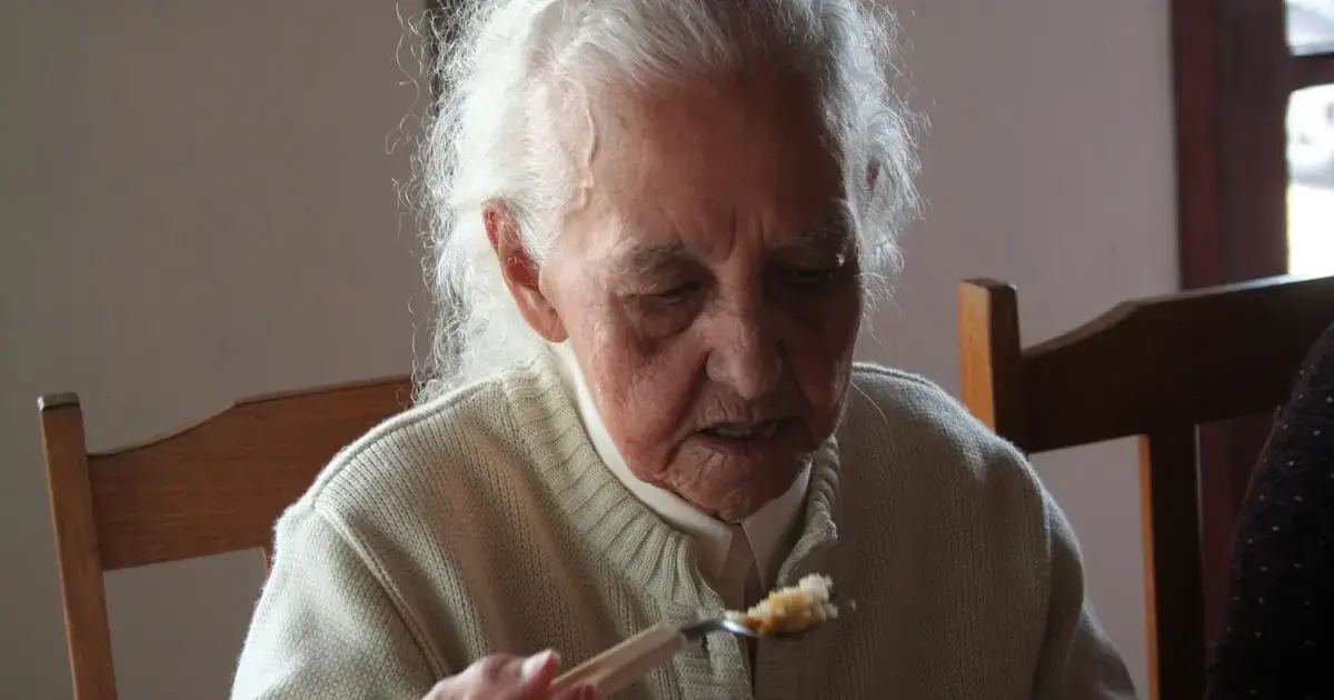 10 Unexpected Early Signs of Dementia to Watch For 4 An elderly woman eating with a spoon.