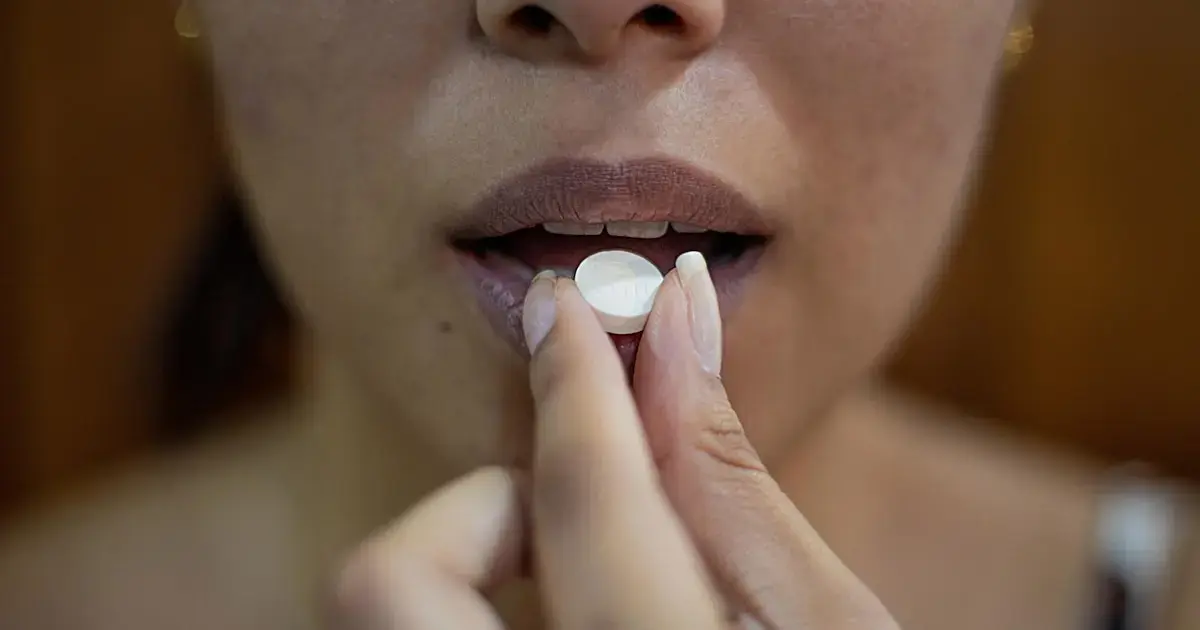 Which Vitamins and Minerals Work Together — and Which You Should Keep Apart 4 A woman taking a pill