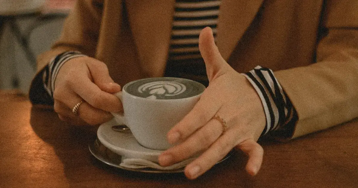 A woman gently strokes a cup with her finger.