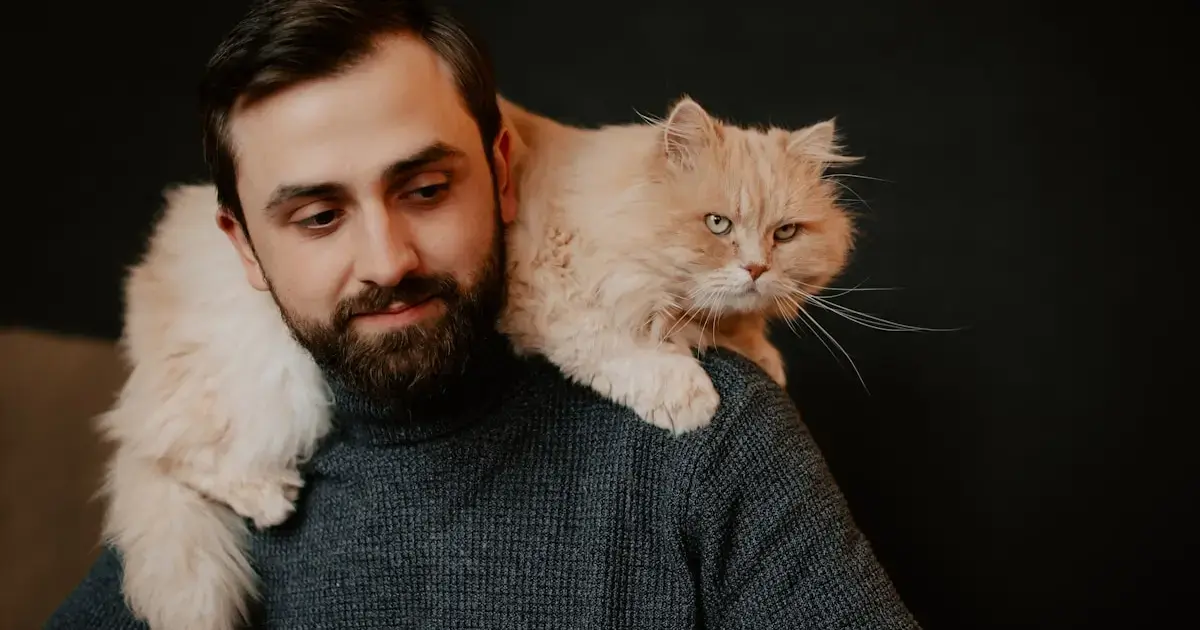 A man with a cat on his shoulders.