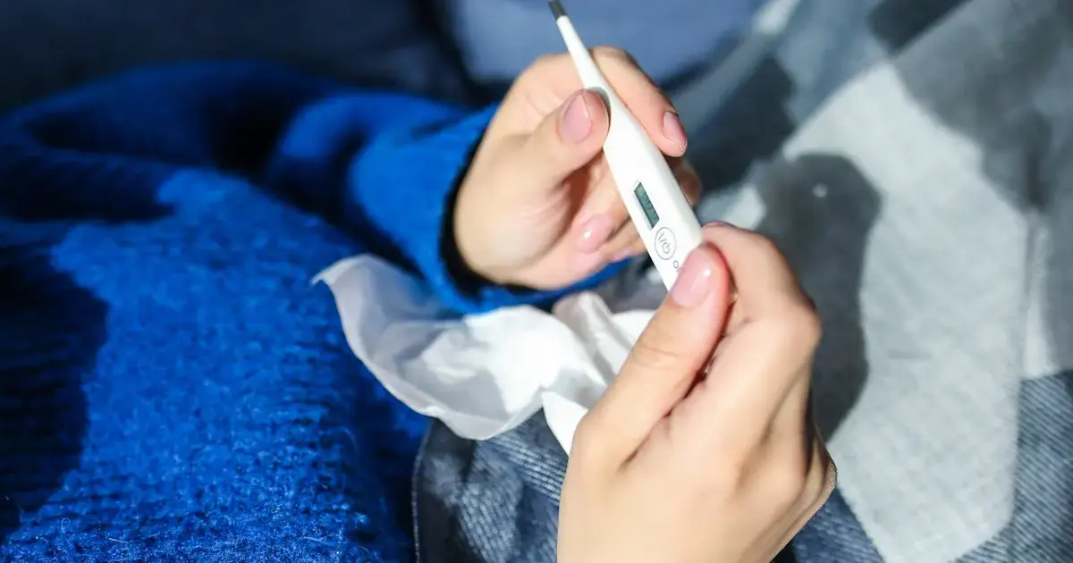 6 Winter Warning Signs Your Body Is Sending 5 a woman holding a thermometer