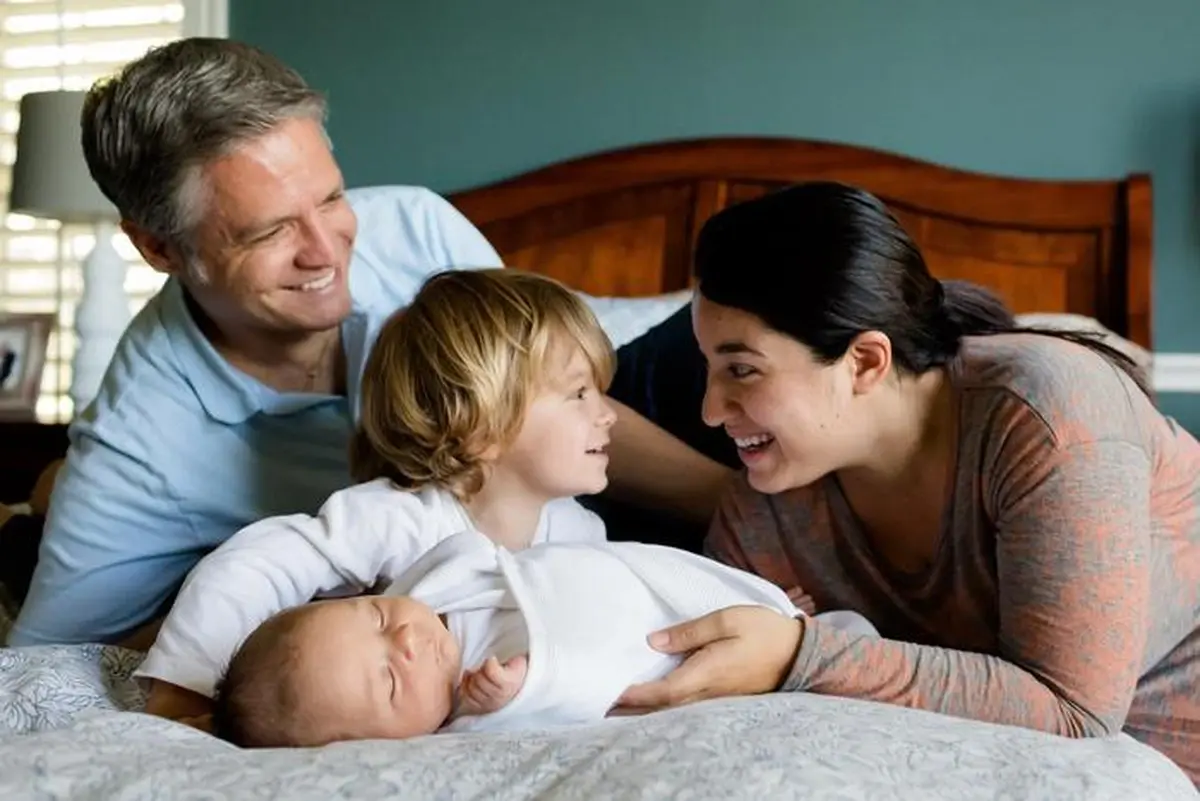 Want Kids? You're More Likely to Prefer Older, More Mature Partners 4 a man and a woman with children on a bed