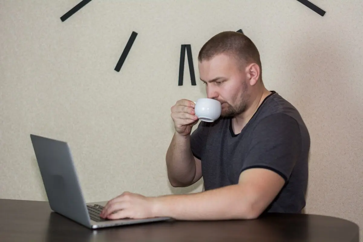 A man with a coffee in the office.