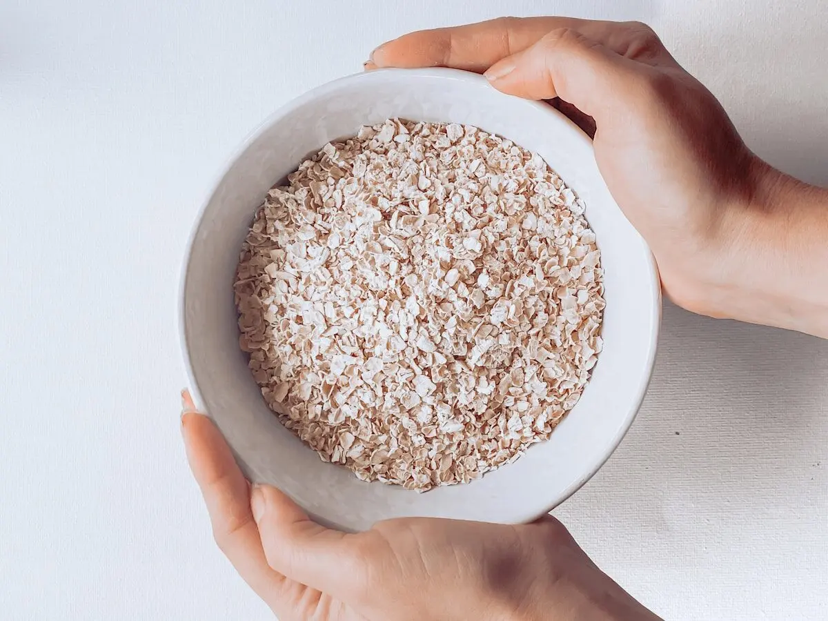 Hands holding a bowl of porridge.