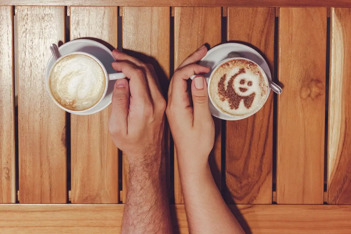 Two to three cups of coffee a day cuts stress and lowers risk of anxiety and depression 4 A man's and a woman's hands holding cups of coffee.