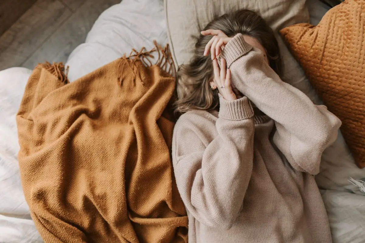 Exploding Head Syndrome: The sudden phantom noise 30% of people hear during sleep transitions 5 A woman in bed covering her face with her hands.