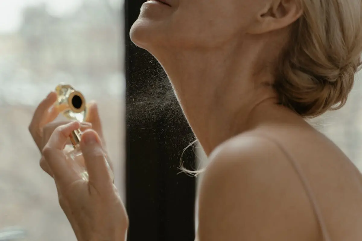 Why Your Perfume Fades So Fast — and How to Make It Last 4 A woman sprays perfume on her neck.