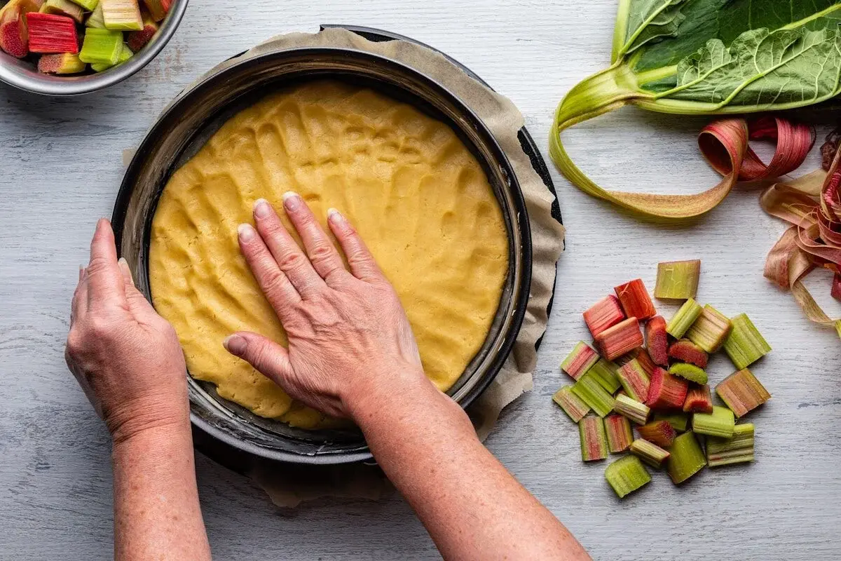 person pressing dough into a pan