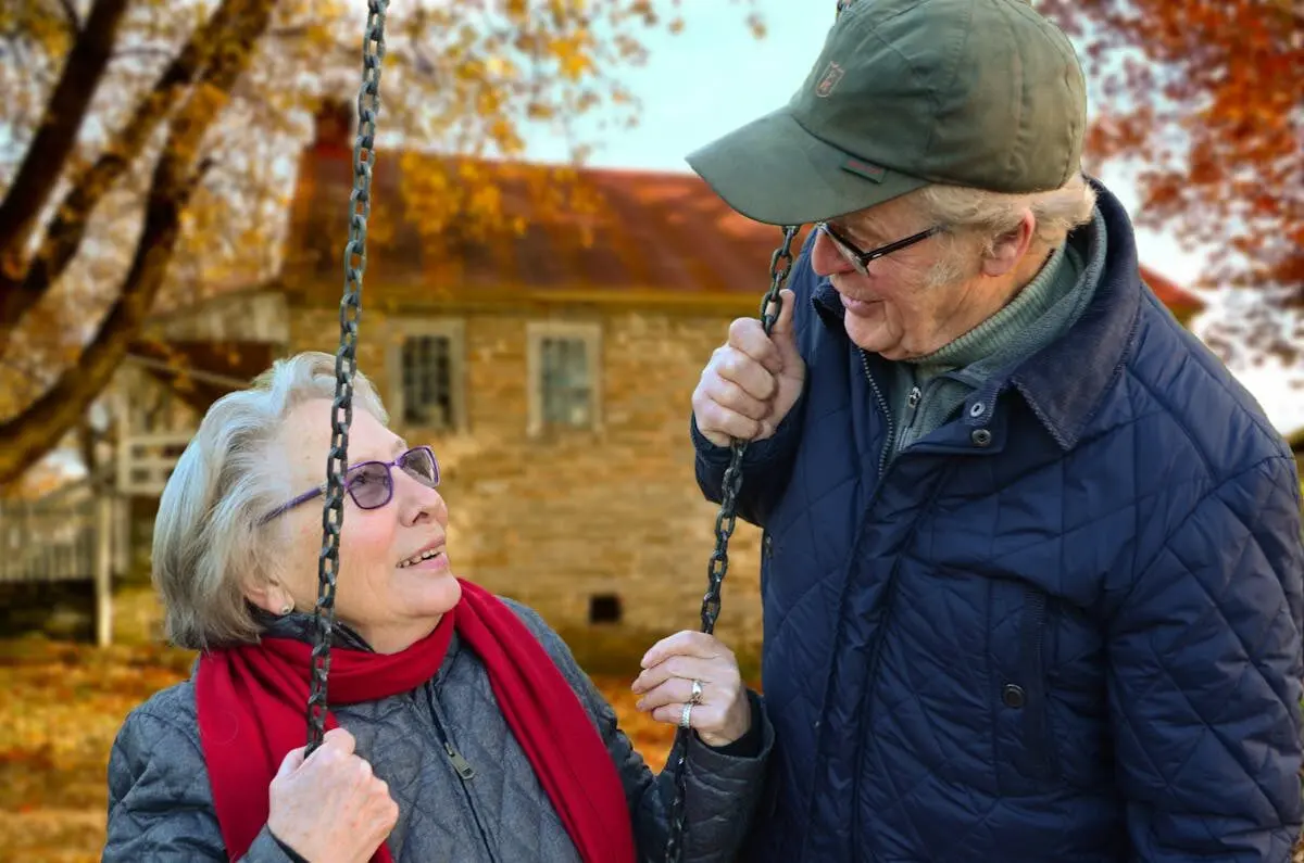An elderly couple on a swing
