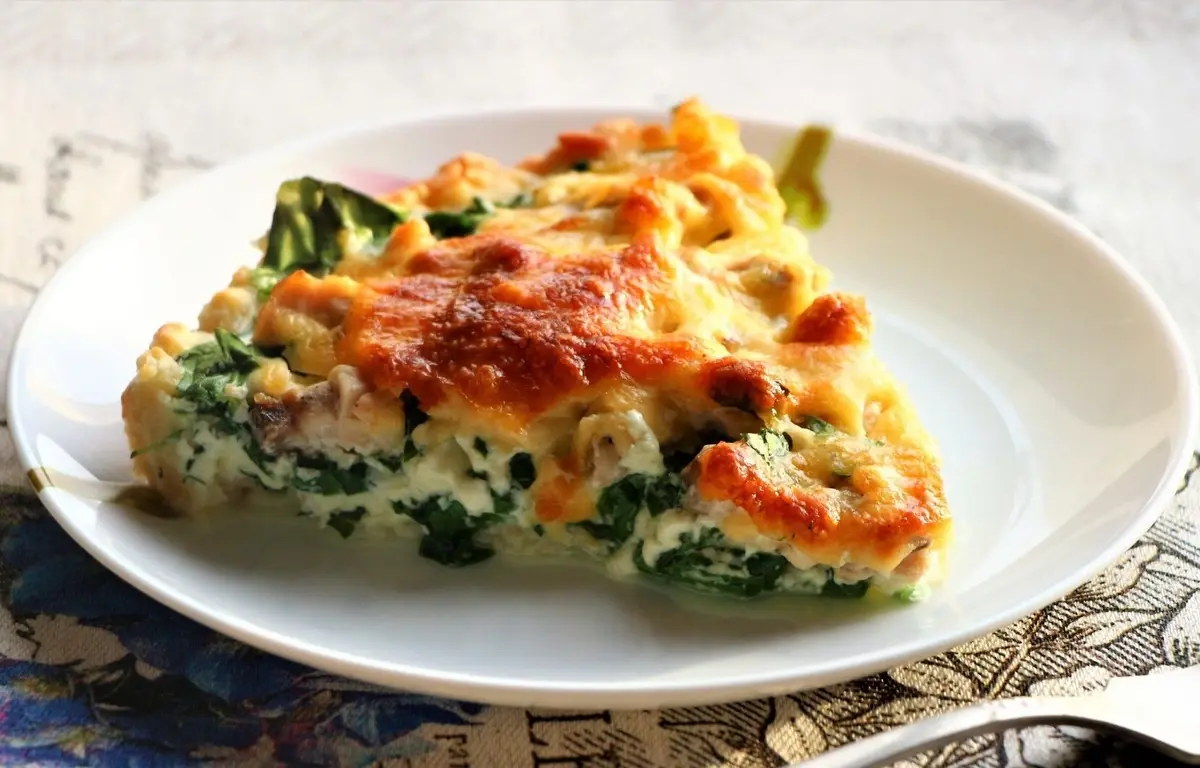 Slice of pie with salmon, spinach, and green peas