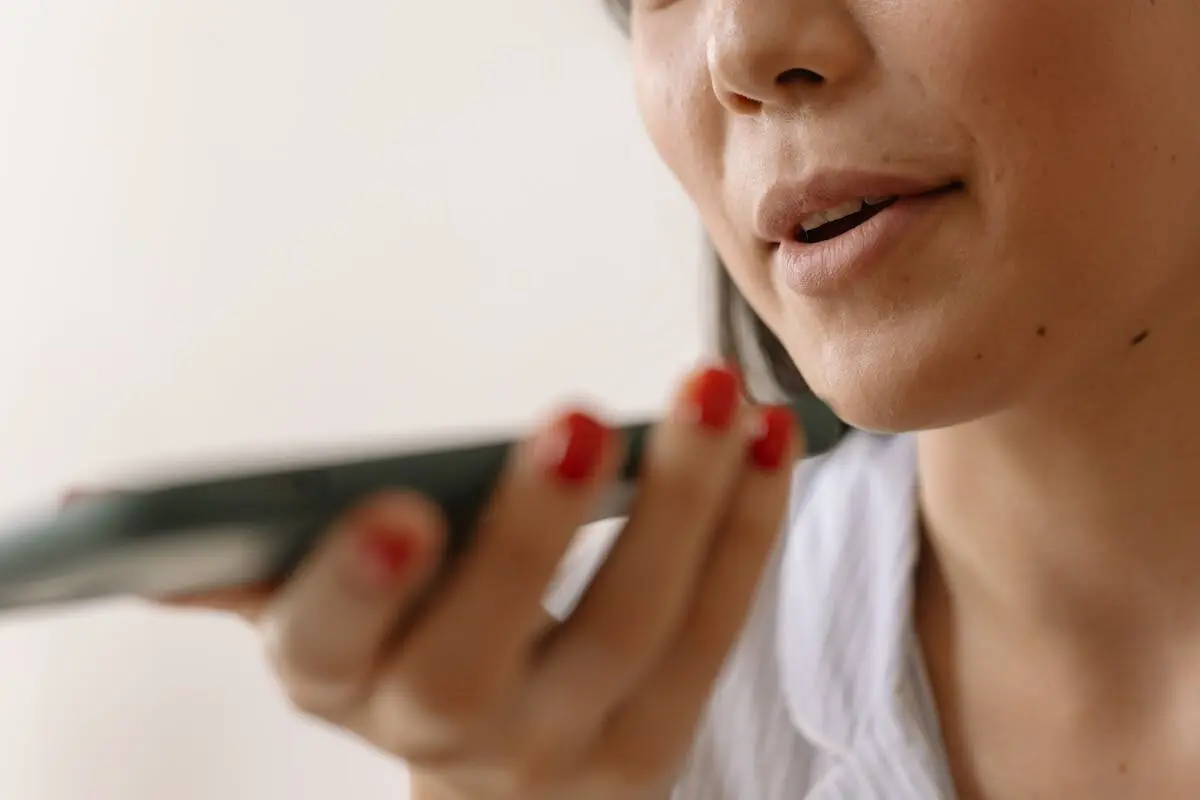 Woman speaking into a phone microphone