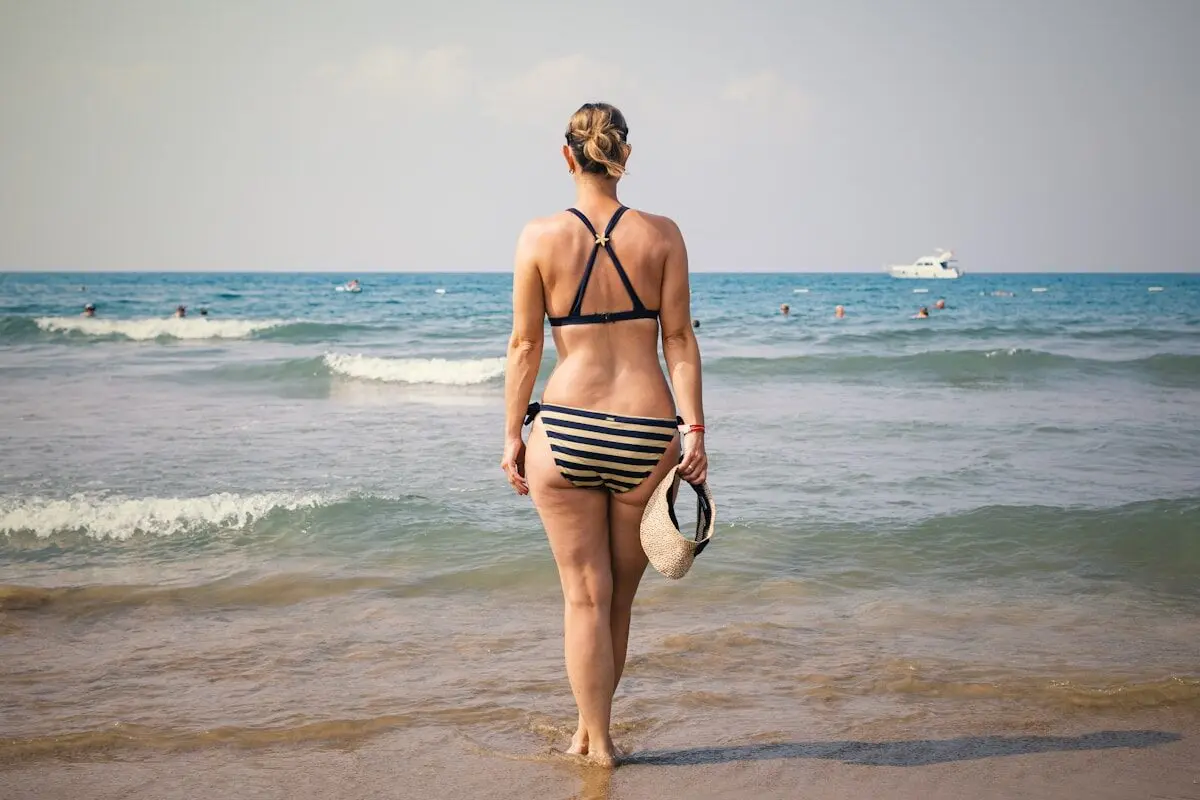 Six Physical Traits Men Notice First on Dating Apps 5 woman in a swimsuit on a beach